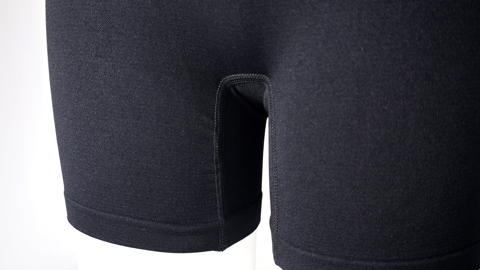 Macro close-up of crotch gusset seam engineering on high-density knitted activewear, visually answering the common question "should I wear underwear under compression shorts" by demonstrating our zero-chafing manufacturing solutions.