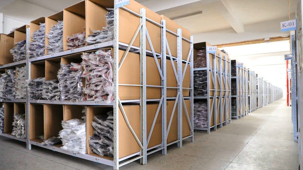 A view of Maes's organized factory warehouse filled with bulk activewear production orders, demonstrating consistent quality and scalable capacity for global brands.