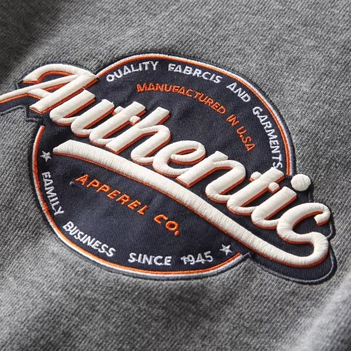 A macro close-up photograph of high-density, premium sportswear logo embroidery, highlighting the flawless stitching details delivered by Maes's modern manufacturing facilities