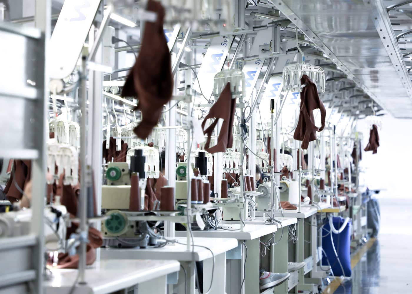 Systematic production line in a professional activewear factory showing specialized sewing stations for OEM and ODM custom garment manufacturing.