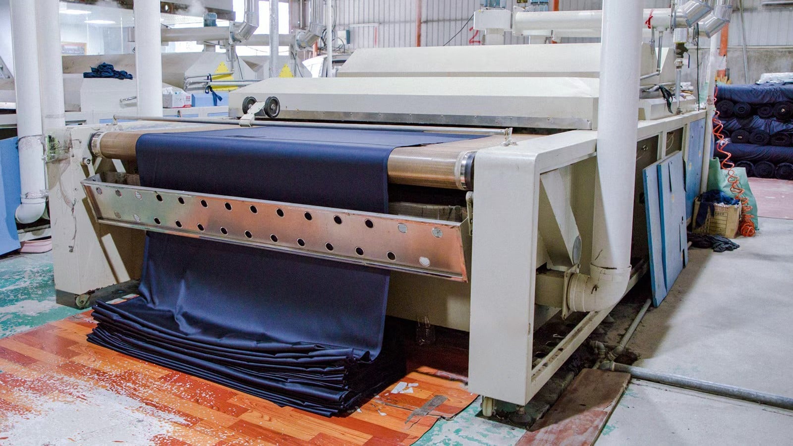 Fabric being relaxed on an open-width pre-shrinking machine before cutting"