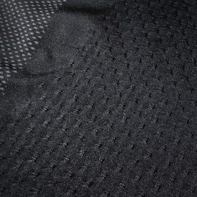 Macro view of advanced 3D jacquard textures featuring honeycomb patterns and technical mesh zones for high-performance seamless activewear.